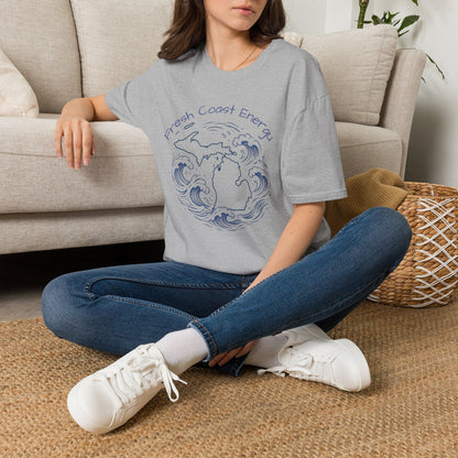 Person sitting on a carpeted floor wearing a gray t-shirt with State of Michigan design, surrounded by waves