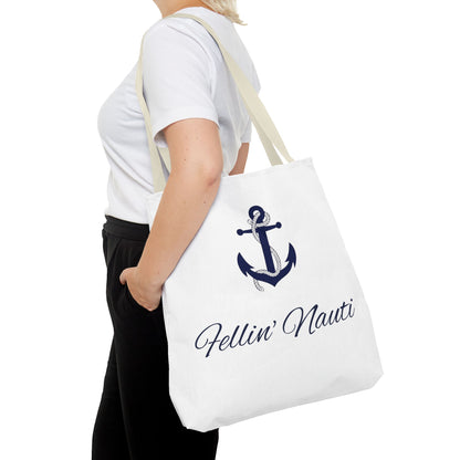 A person wearing a white t-shirt and black pants carries a white canvas tote bag with a navy blue anchor graphic and the text 'Fellin' Nauti' in cursive script.
