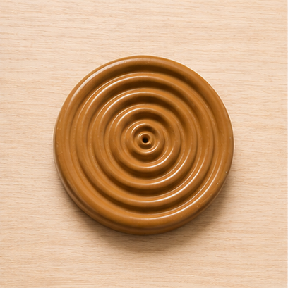 Brown circular object with concentric rings on a beige background
