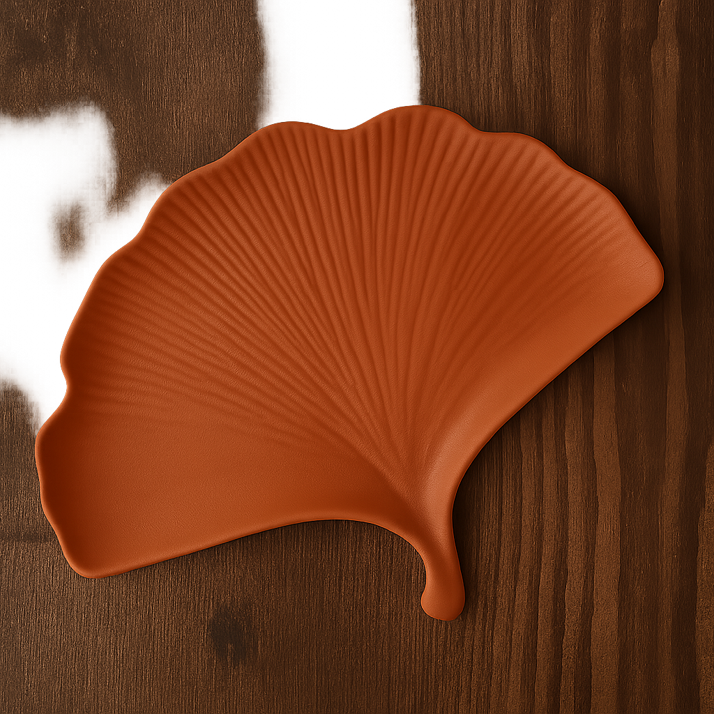 Brown leaf-shaped ceramic plate on a wooden surface