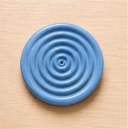 Blue circular object with concentric circles on a beige background