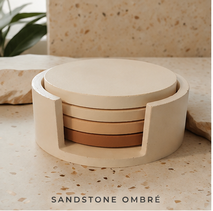 A set of round coasters in a sandstone ombré color palette, stacked inside a matching cylindrical holder. The coasters transition from cream to light tan and terracotta.